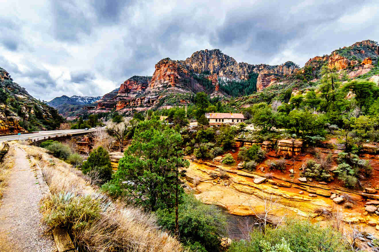 Sedona's rugged landscape with a river cutting through red rock valleys, as seen from an elevated viewpoint with overcast skies